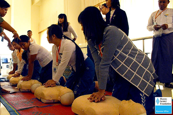 Workshop participants practicing CPR on training dummies.