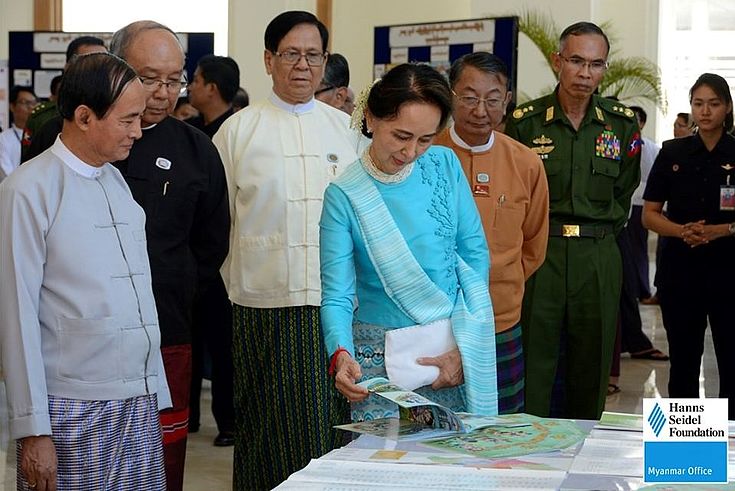 Daw Aung San Su Kyi looking at parliament related publications by the Hanns Seidel Foundation