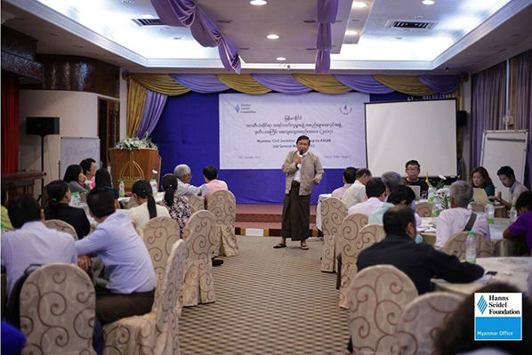A speaker standing in front of the participants delivering his talk