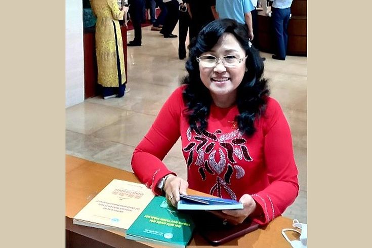 A NA deputy happily received 3 handbooks at the hall of the conference room during the 1st sesison of the 15th NA of Vietnam.