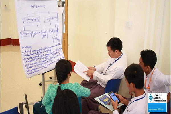 Participants were told to prepare a mock press release on the topic of how to ban plastic bags in Myanmar. Here they discuss ideas and draft a press release on the poster.