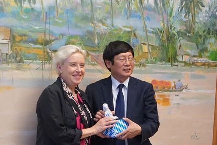 Dr. Susanne Luther and Mr. He Do Manh Hung exchange gifts
