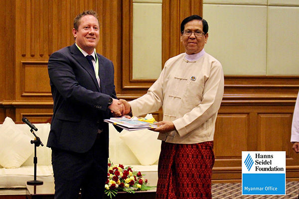 Mr. Achim Munz hands over the publications, which were jointly developed by HSF and the Hluttaw to H.E. U Aye Thar Aung.